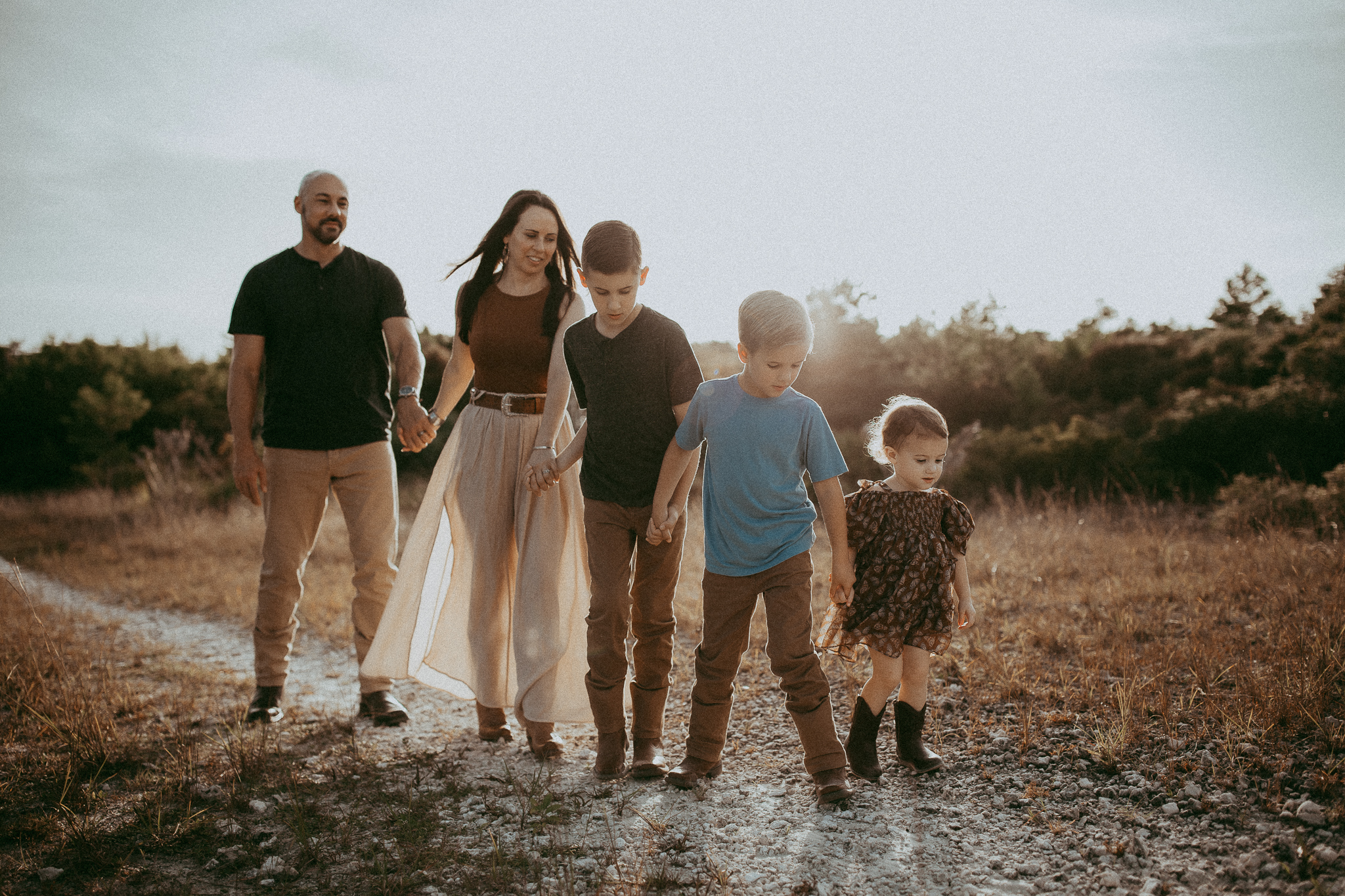 Family of 5 walking and holding hands in a park
